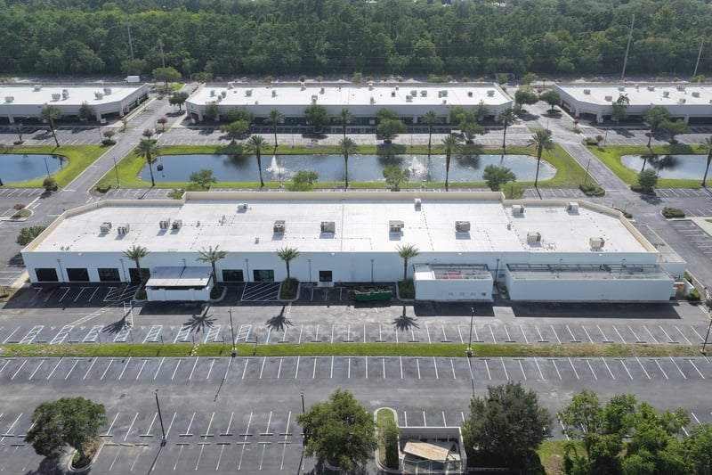 Aerial view of a long roofline with ponds and palm-lined walk at 10550 Deerwood Park Blvd, Jacksonville, FL 32256