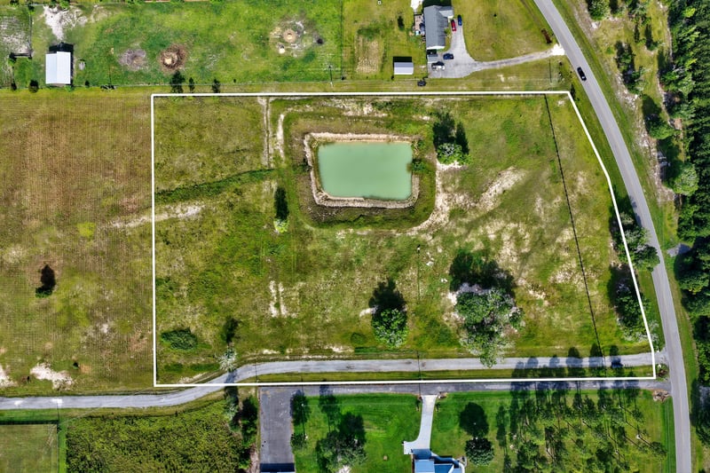 Aerial view with property boundary lines marked around a pond and home site at 7500 Lucky Seven Rnch Rd, Macclenny, FL