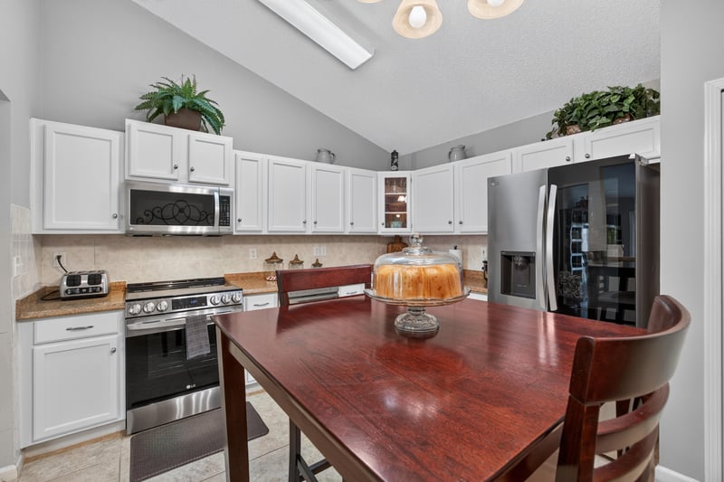 Kitchen with dining table and stainless refrigerator at 3067 Wavering Ln, Middleburg, FL 32068