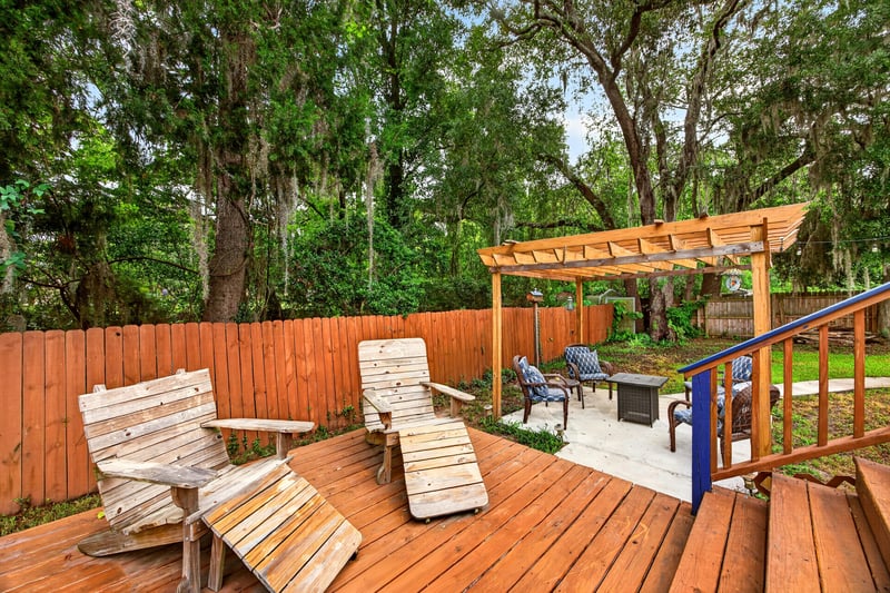 Backyard patio with pergola and wood chairs at 981 Marble Ridge Dr, Orange Park, FL 32065