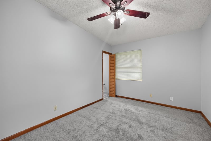 Carpeted bedroom with ceiling fan and window at 11462 Elane Dr, Jacksonville, FL