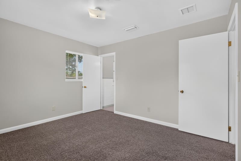 Carpeted bedroom with closet door at 2618 Arlex Dr E, Jacksonville, FL