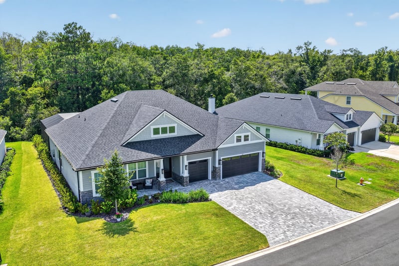 Aerial front view with mature trees behind the home at 785 Back Creek Dr, St. Augustine, FL 32092
