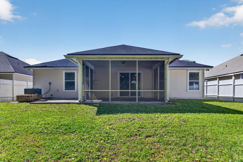 Rear exterior with screened porch and lawn at 14147 Fish Eagle Dr E, Jacksonville, FL 32226