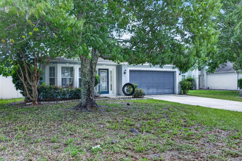 Front exterior shaded by trees at 1845 Saga Ct, Middleburg, FL