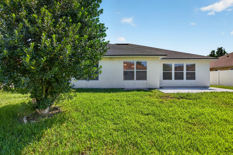 Backyard with grass and young tree at 2282 Justin Lake Dr, Jacksonville, FL
