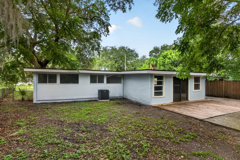 Rear exterior view with oak trees and deck at 3113 Kline Rd, Jacksonville, FL 32246