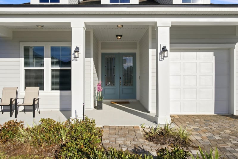 Front porch seating area with paver driveway and garage at 27 Holly Rdg Wy, St. Augustine, FL