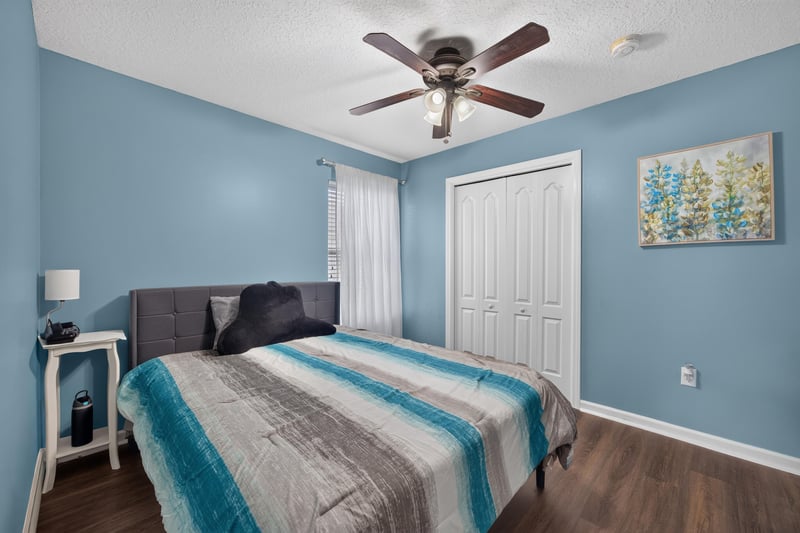 Secondary bedroom with striped bedding at 3112 Silverado Cir, Green Cove Springs, FL 32043