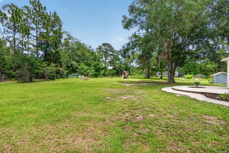Open grassy yard with shed in the distance at 4890 McAllister Rd, Middleburg, FL 32068