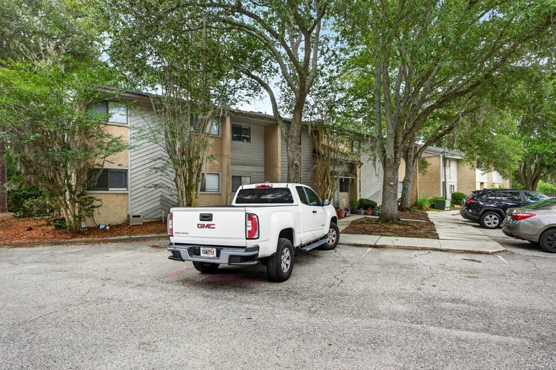 Condo building exterior with parking and trees in Jacksonville, FL