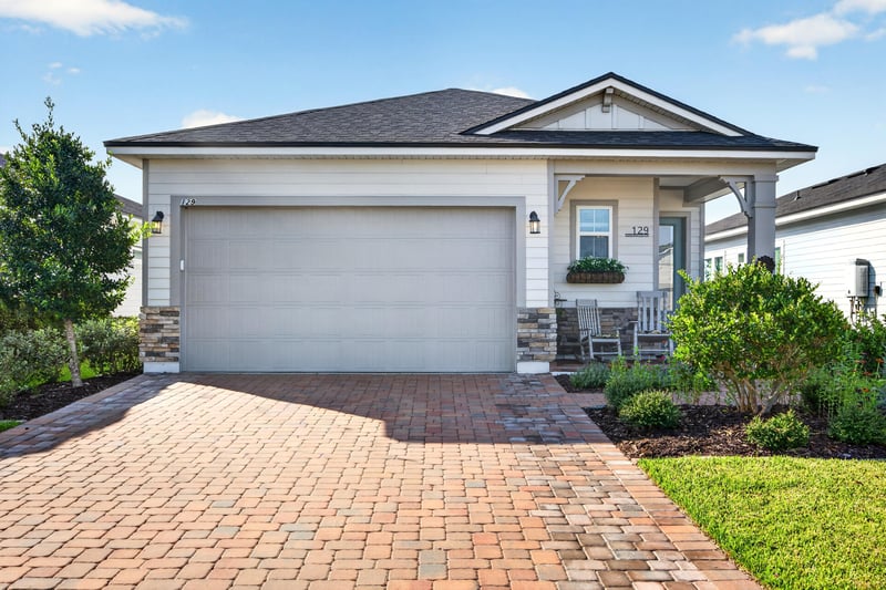 Front exterior with paver driveway and covered entry at 129 Amberwood Dr, St. Augustine, FL
