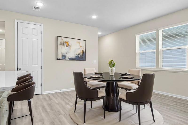 Staged dining area with round table and chairs at 7088 Mahogany Run Dr, Jacksonville, FL 32244