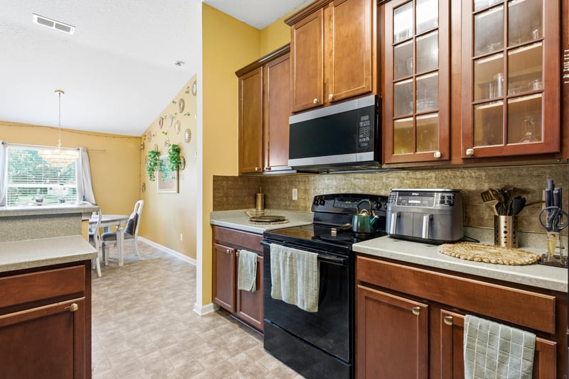 Kitchen with black appliances and tile backsplash at 7392 Timber Falls Ct