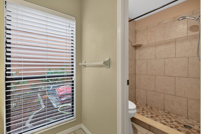 Bathroom with tiled shower and window blinds at 3515 Cormorant Branch Ct, Jacksonville, FL