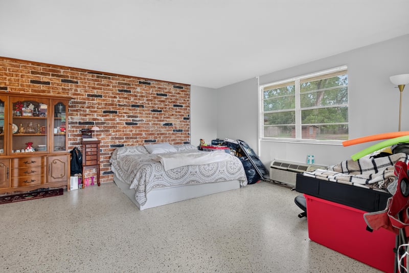 Bedroom with brick accent wall and bed at 5745 110th St, Jacksonville, FL 32244