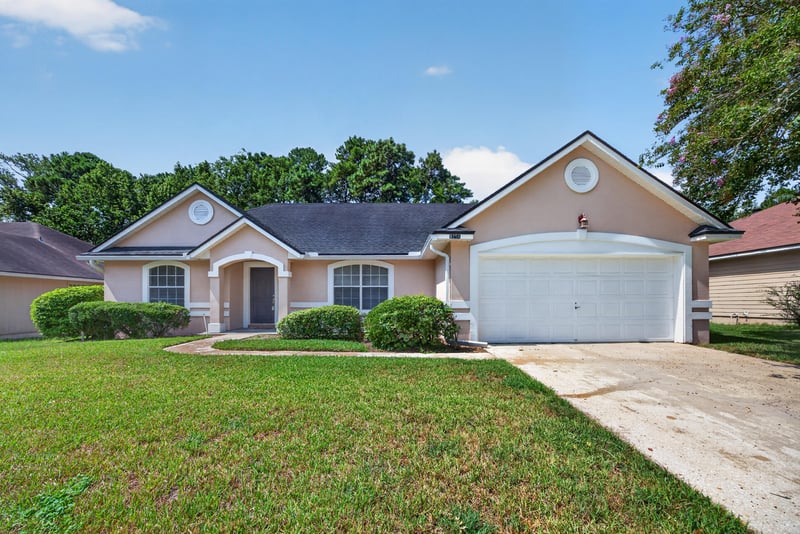 Front exterior with landscaped yard and driveway at 9256 Dale View Ln W, Jacksonville, FL 32225