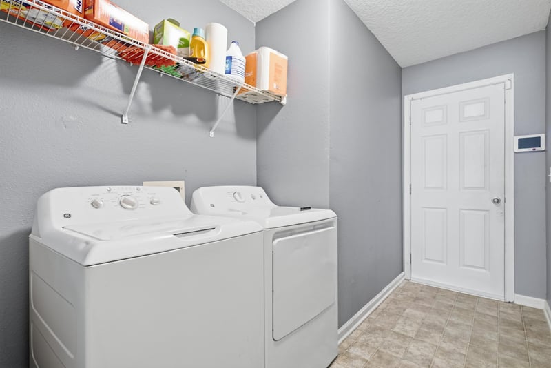Laundry room with wire shelving and washer-dryer at 7392 Timber Falls Ct