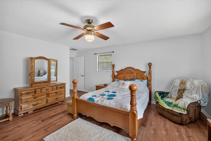 Bedroom with wood bed frame and dresser at 2435 Range Line Rd, Middleburg, FL