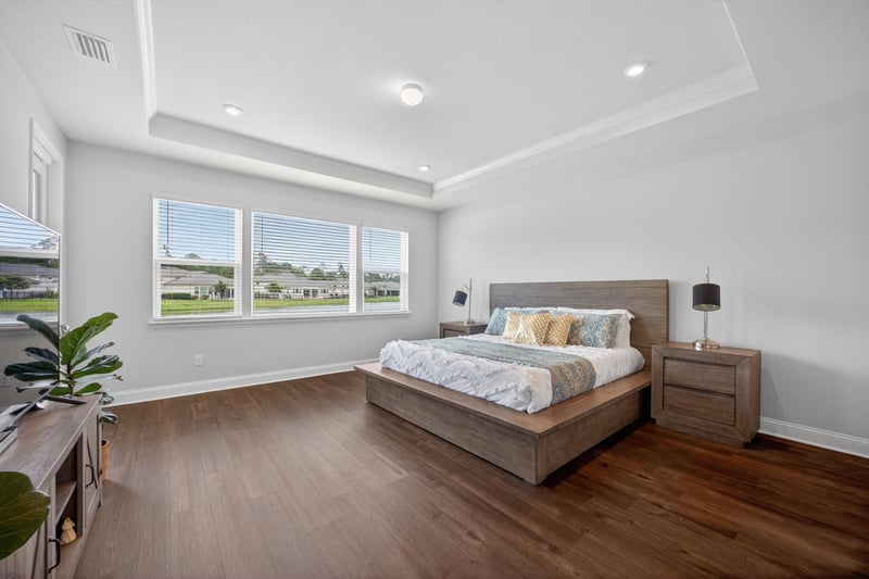Primary bedroom with tray ceiling and large windows at 85491 Fall River Pkwy, Fernandina Beach, FL 32034