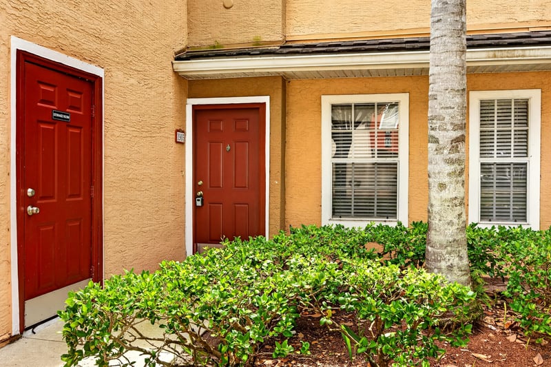 Red front door framed by greenery at 10075 Gate Pkwy unit 1905, Jacksonville, FL 32246
