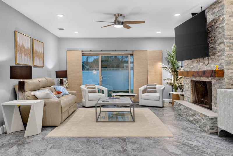 Living room with fireplace and pool-view windows at 1525 8th St N, Jacksonville Beach, FL