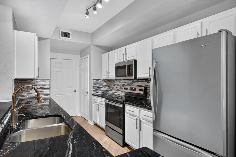 Kitchen with granite counters, double sink, and stainless appliances at 10075 Gate Pkwy unit 1905, Jacksonville, FL 32246