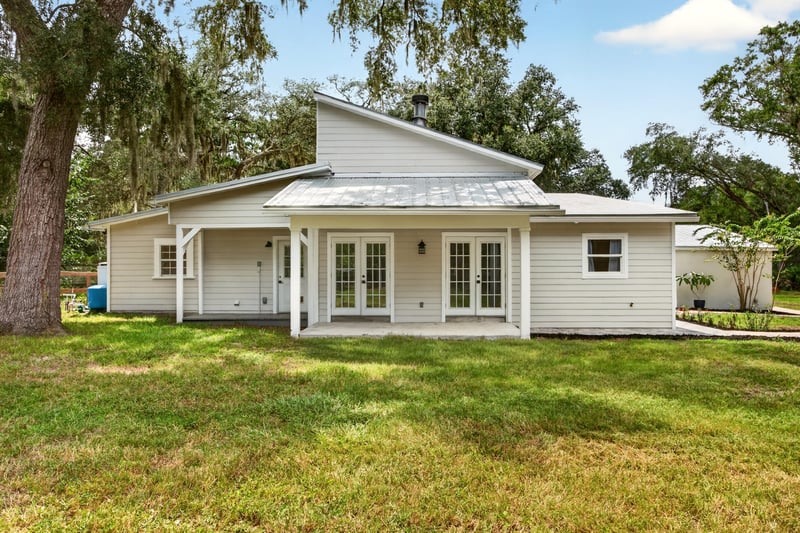 Rear exterior with covered porch and lawn at 1161 Whispering Pines Rd, Jacksonville, FL 32259