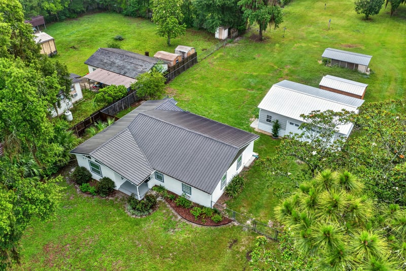 Aerial view of the property with outbuildings and trees at 1619 Hammond Blvd, Jacksonville, FL