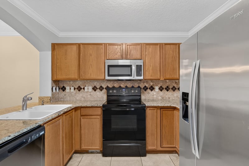 Kitchen with tile backsplash and black range at 353 Redwood Ln