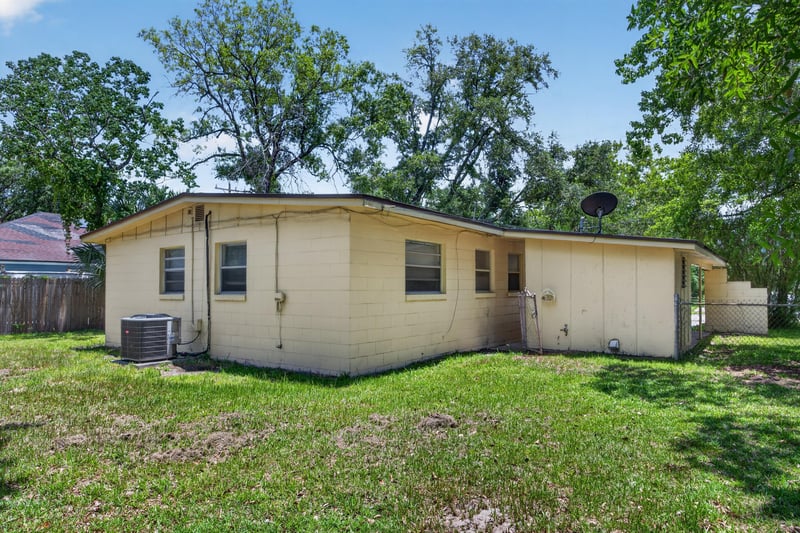Rear exterior with AC unit and open lawn at 5527 Beney Rd, Jacksonville, FL 32207