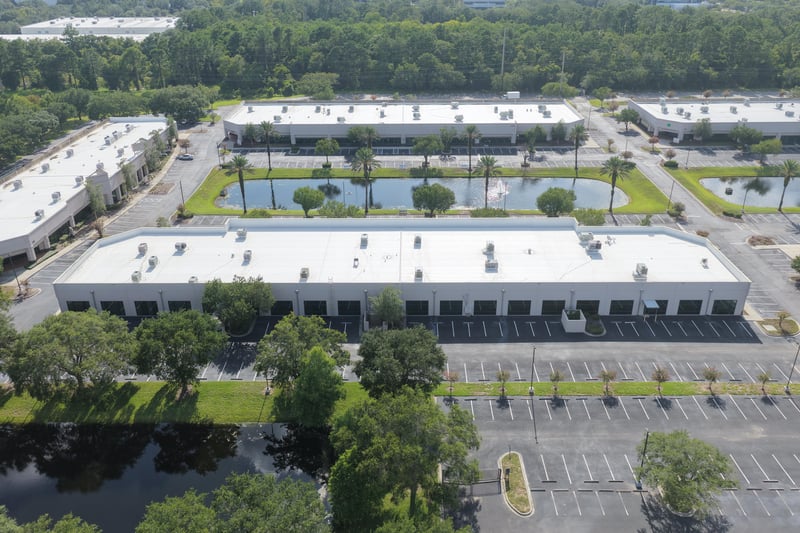 Aerial view of a long roofline with two ponds and palm trees at 10550 Deerwood Park Blvd, Jacksonville, FL 32256