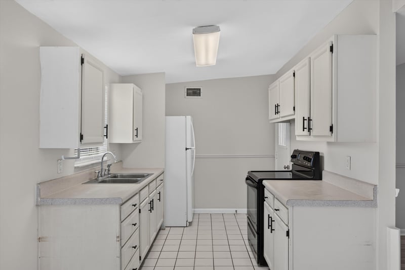 Kitchen with white cabinets and tile floor at 87 Saratoga Cir S, Atlantic Beach, FL