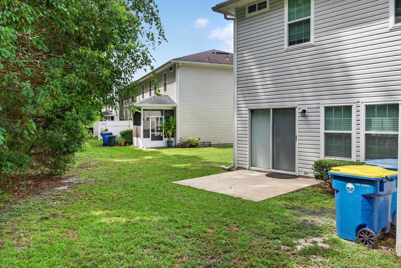 Backyard patio with trees and bins at 12359 Mangrove Forest Ct, Jacksonville, FL 32218