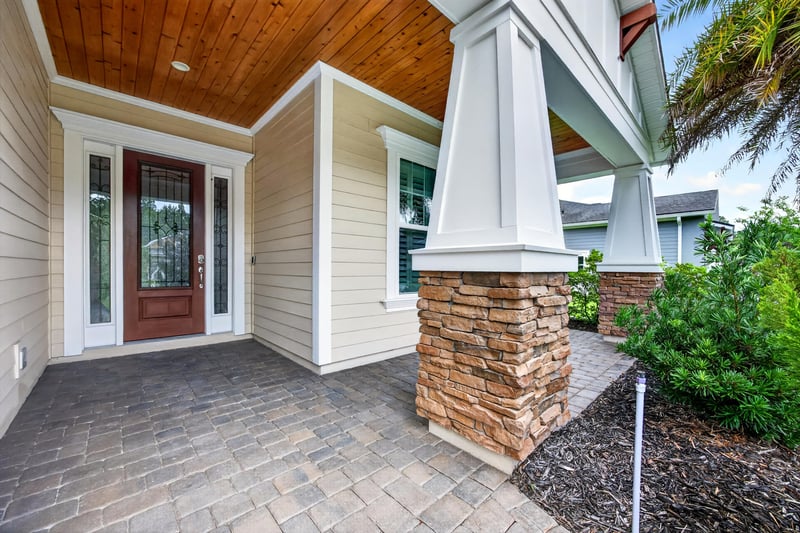 Covered front entry with stone column and glass door at 186 Freshwater Dr