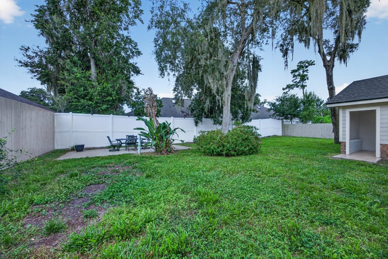 Backyard at day-to-dusk with fence and open lawn at 12344 Cormorant Ct, Jacksonville, FL
