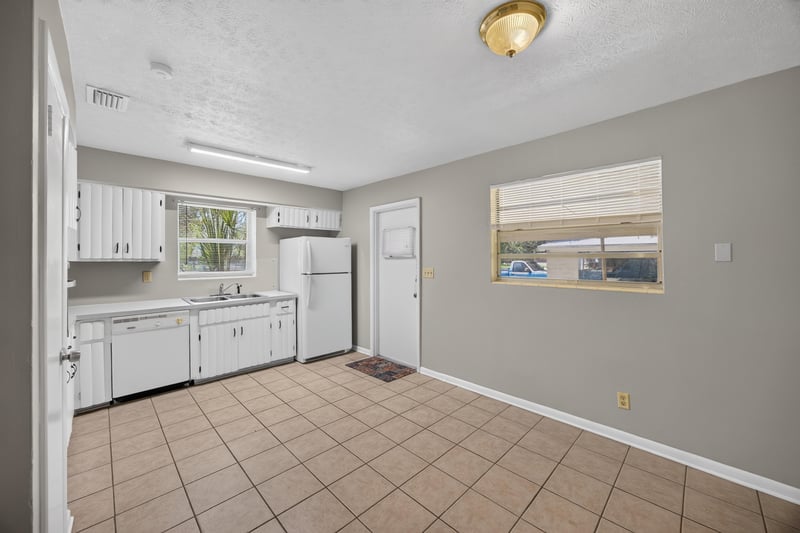 Kitchen with white cabinets and tile flooring at 5527 Beney Rd, Jacksonville, FL 32207