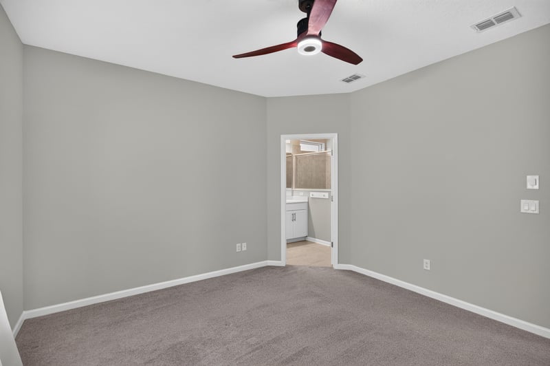 Carpeted bedroom with closet door and ceiling fan at 75875 Saffron Ln, Yulee, FL 32097