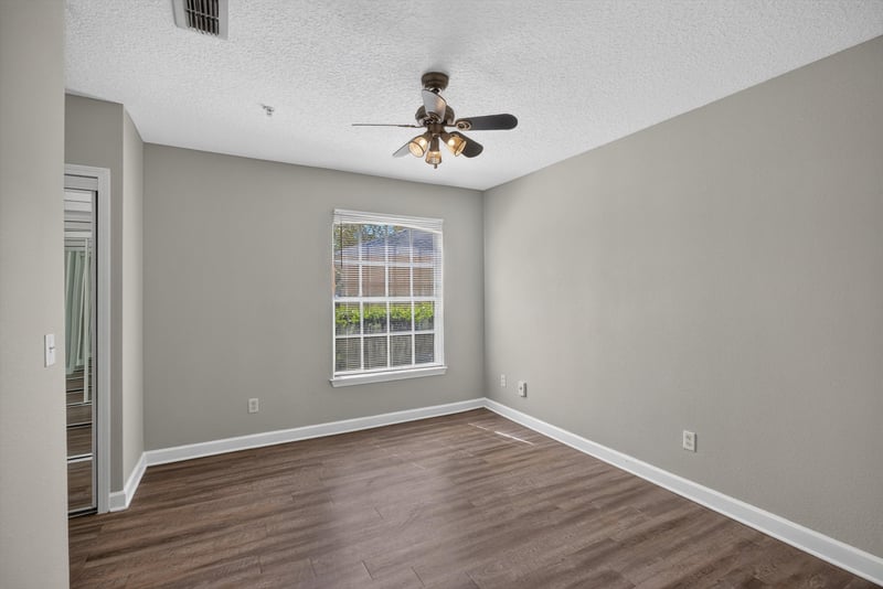 Bedroom with window and hardwood floors at 1701 The Greens Way 1415, Jacksonville Beach, FL 32250