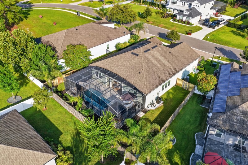 Aerial view of the home with pool enclosure and street at 3328 Southern Oaks Dr, Green Cove Springs, FL 32043