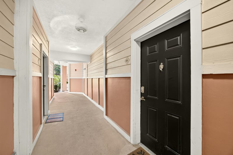 Carpeted hallway leading to the unit's front door at 10435 Mid Town Pkwy unit 135, Jacksonville, FL 32246
