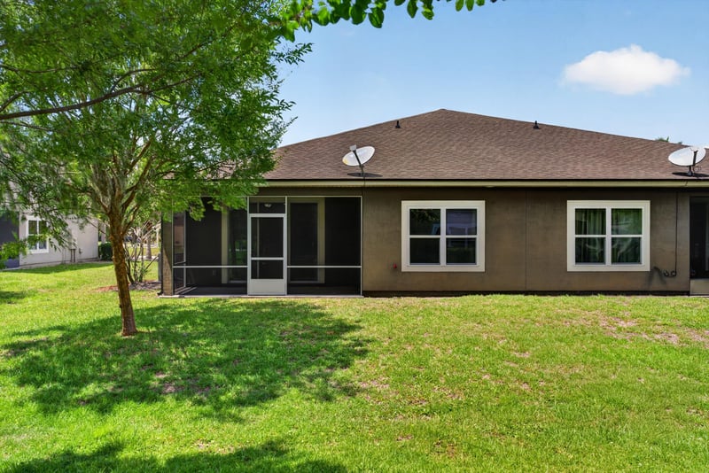 Backyard lawn with trees and rear elevation at 2378 Caney Oaks Dr, Jacksonville, FL