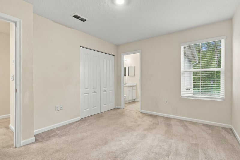 Empty bedroom with closet door and carpet at 9555 Star Dr, Jacksonville, FL 32256