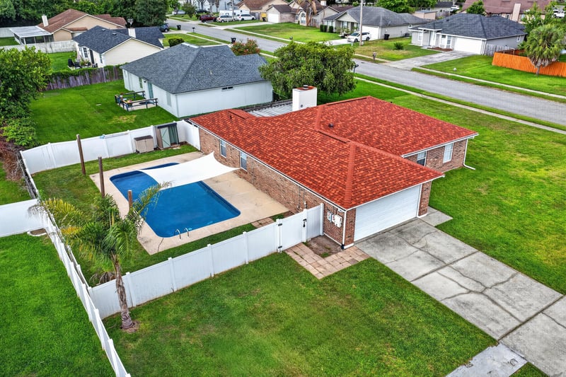 Aerial angled view of the home with pool and patio at 2164 Orangewood St, Middleburg, FL 32068