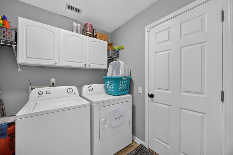 Laundry room with white cabinets and washer dryer at 12825 Kelsey Island Dr, Jacksonville, FL 32224
