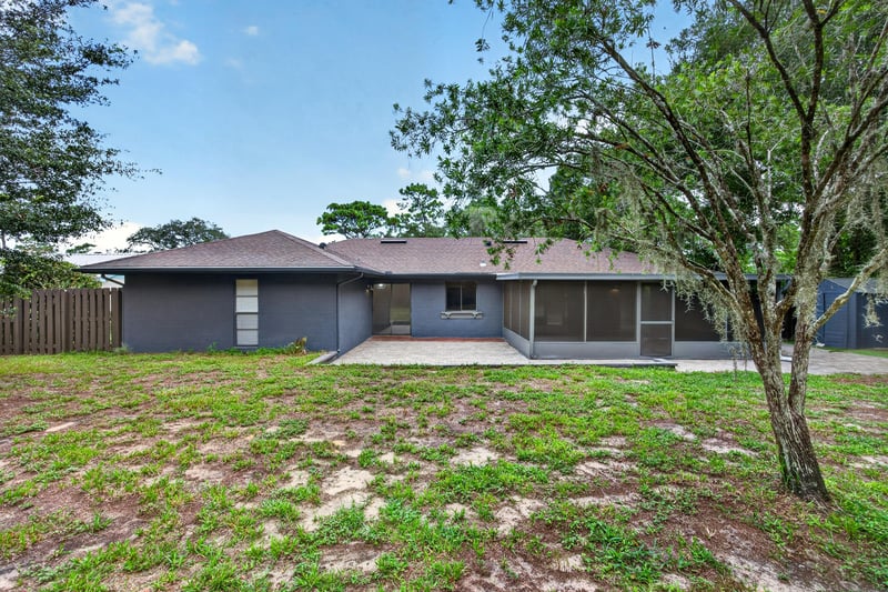 Rear exterior with blue siding and screened porch at 551 Deltona Blvd, St. Augustine, FL 32086