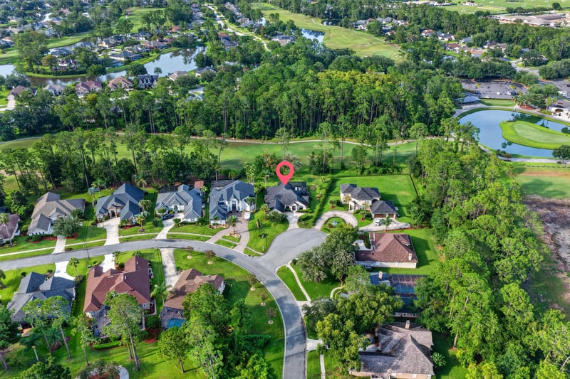 Aerial view of neighborhood with pond and golf course in Orange Park, FL