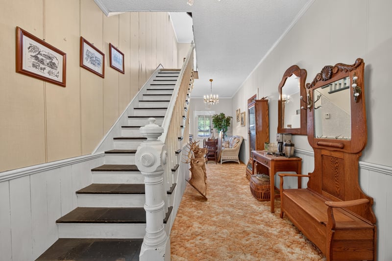 Entry hall with staircase and antique furnishings at 1173 US-17, Satsuma, FL 32189