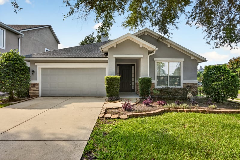 Front exterior with two-car garage and oak tree at 3101 E Banister Rd, St. Augustine, FL 32092