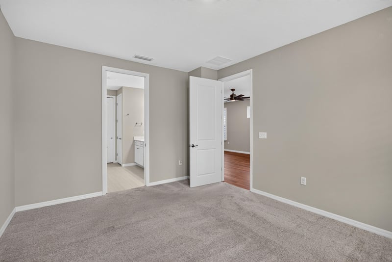 Hallway with carpet leading to bathroom and closet doors at 171 Oyster Shell Ter, Nocatee, FL 32081